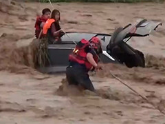 河南三门峡两人被困河中 消防员洪水中展开救援