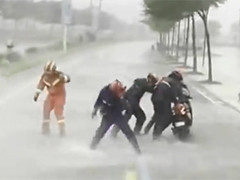 广东阳江市民骑摩托被台风刮倒 消防出手救援