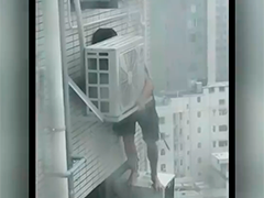 香港一住户爬出窗外加固空调外机 场面触目惊心