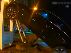 扬州新手"漂移"过弯 汽车"骑"上信号灯杆