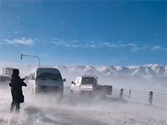 新疆哈密 风吹雪致90余辆车被困 民警清雪疏堵