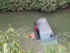 轿车坠河三人被困 众人协力救援