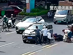 广东 两人被卷车底 众人合力抬车救人