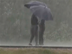 江西遂川暴雨中老人蹒跚独行 热心女子撑伞冲进雨幕